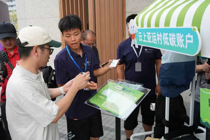 9月12日，工作人員指導(dǎo)媒體記者開啟云上亞運村低碳賬戶。新華社記者翁忻旸攝.jpg