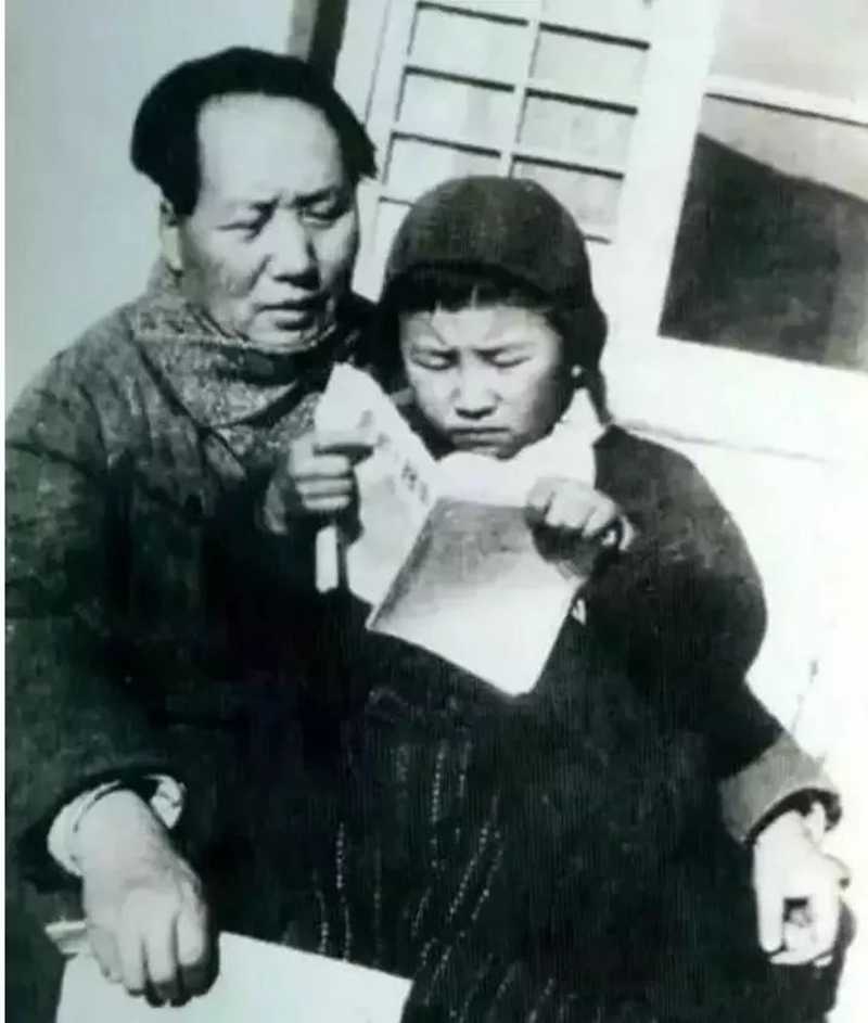 1946年毛澤東在延安窯洞前教女兒李訥識(shí)字。.jpg